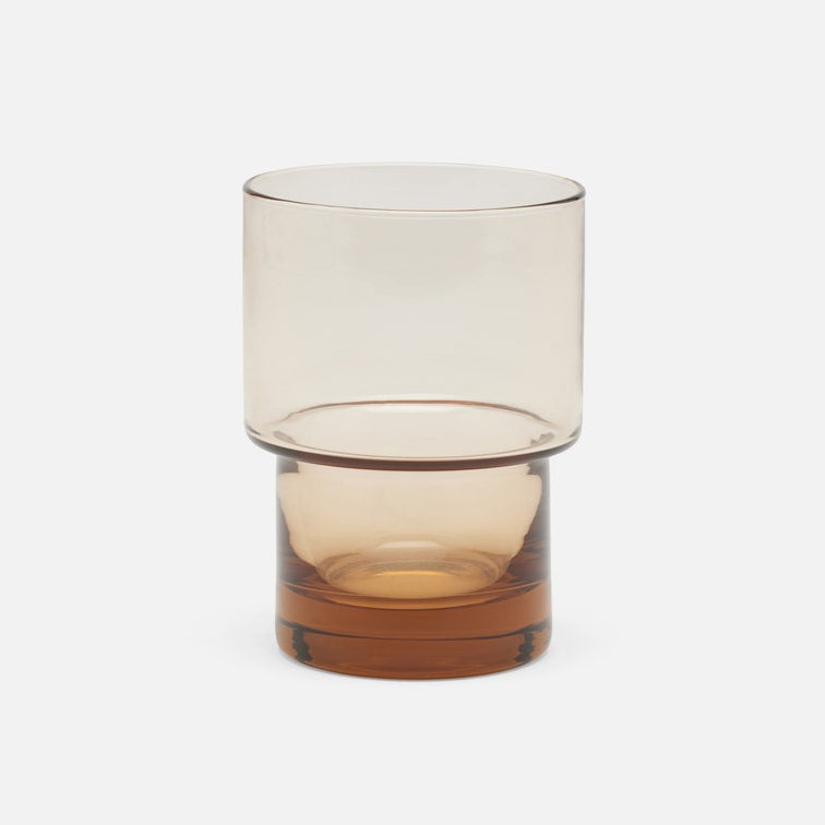 Glass tumbler with gradient color from top to bottom on a white background