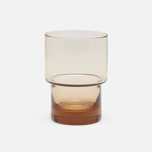 Glass tumbler with gradient color from top to bottom on a white background