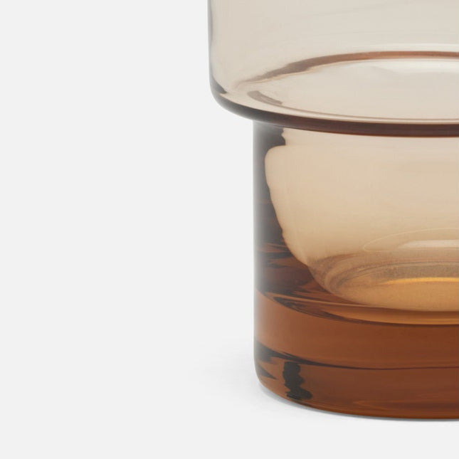 Close-up of a glass with a gradient color transition on a white background