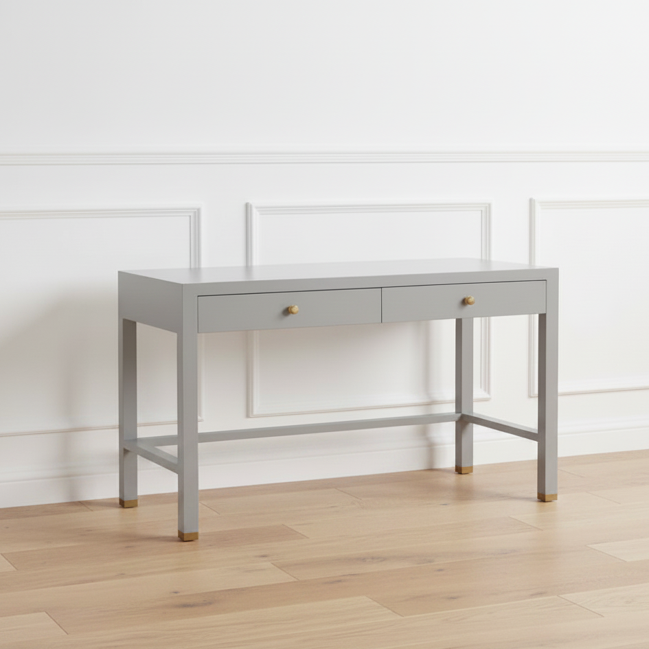 Gray desk with two drawers on a wooden floor against a white wall
