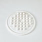 Round white marble trivet with circular pattern on a light gray background