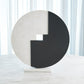Abstract sculpture with a black and white circular design on a white background
