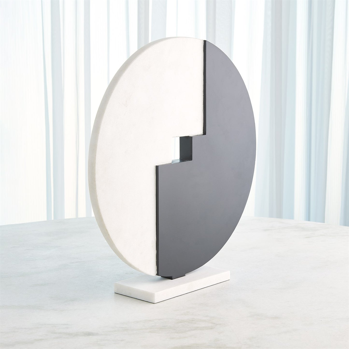 Modern round table lamp with a white base and gray half-circle shade on a light background