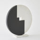 Modern decorative piece with a black and white circular design on a light gray background