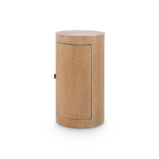 A modern cylindrical side table or cabinet with a light oak wood grain finish, featuring a small brass handle and subtle seam lines, shown on a white background.