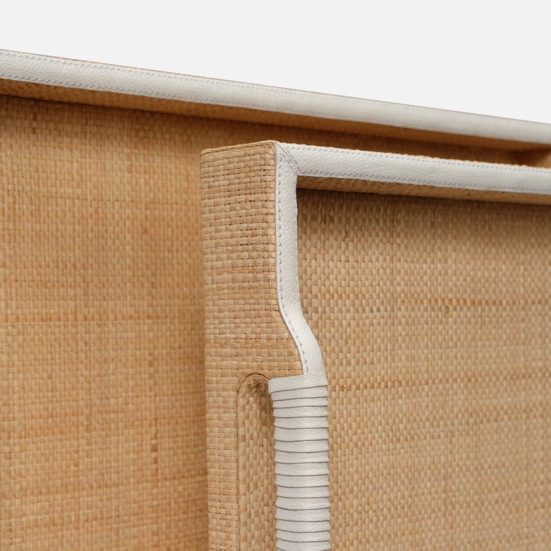 Close-up of a woven blind with a white handle on a light background