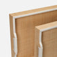 Close-up of a woven wooden frame with white trim on a light gray background