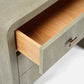 Close-up of a textured gray cabinet with an open wooden drawer and brass handle.