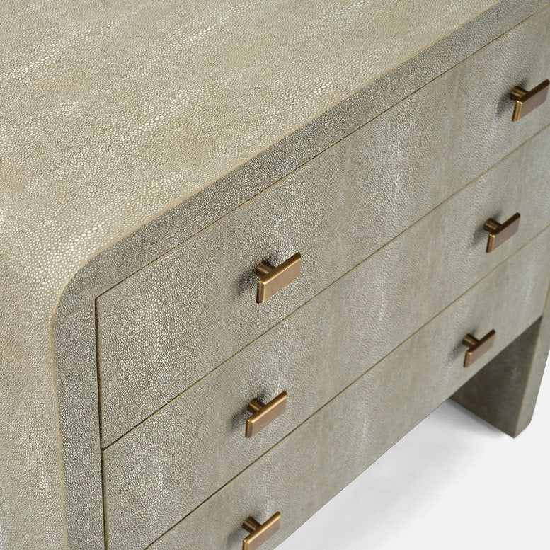 Close-up of a textured dresser with gold handles on a white background
