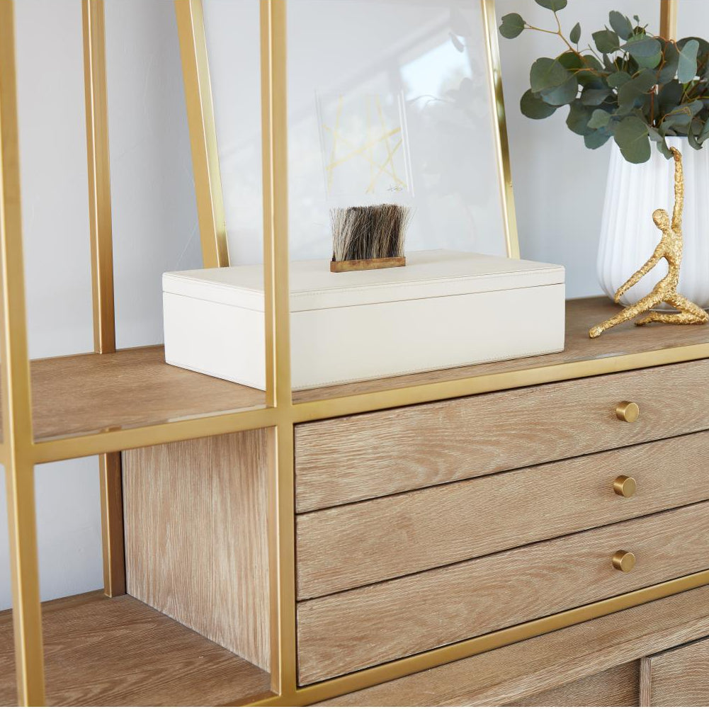Wooden dresser with gold frame and mirror, decorated with a vase and plant.