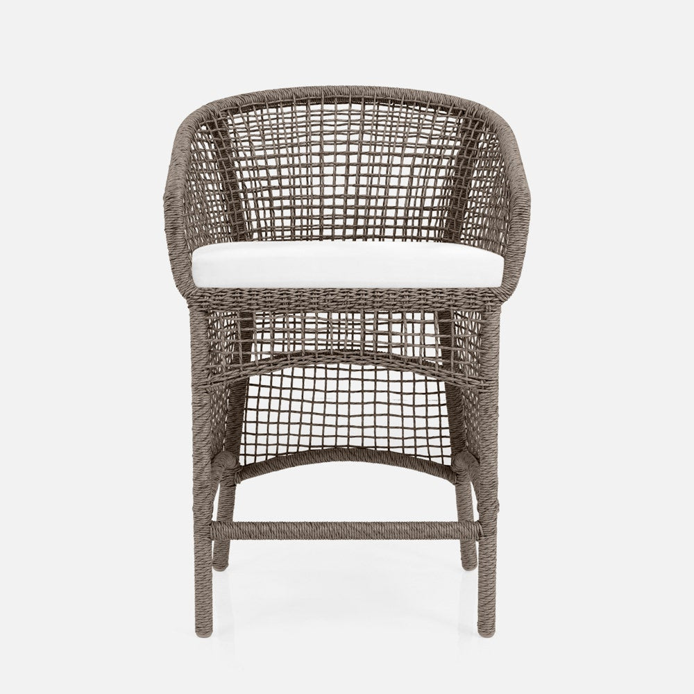 Wicker chair with a white cushion on a light gray background