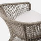 Woven chair with a white cushion on a white background