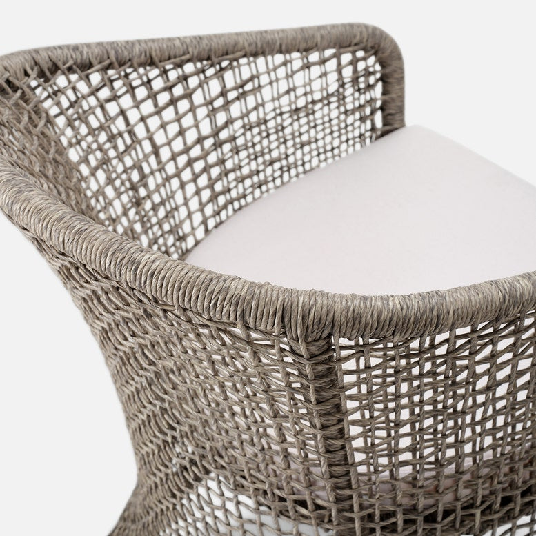 Woven chair with a white cushion on a white background