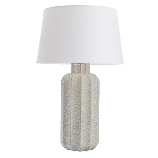 Table lamp with textured base and white shade on a white background