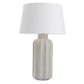 Table lamp with textured base and white shade on a white background