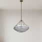 Chandelier hanging in a minimalistic room with white walls and floor.