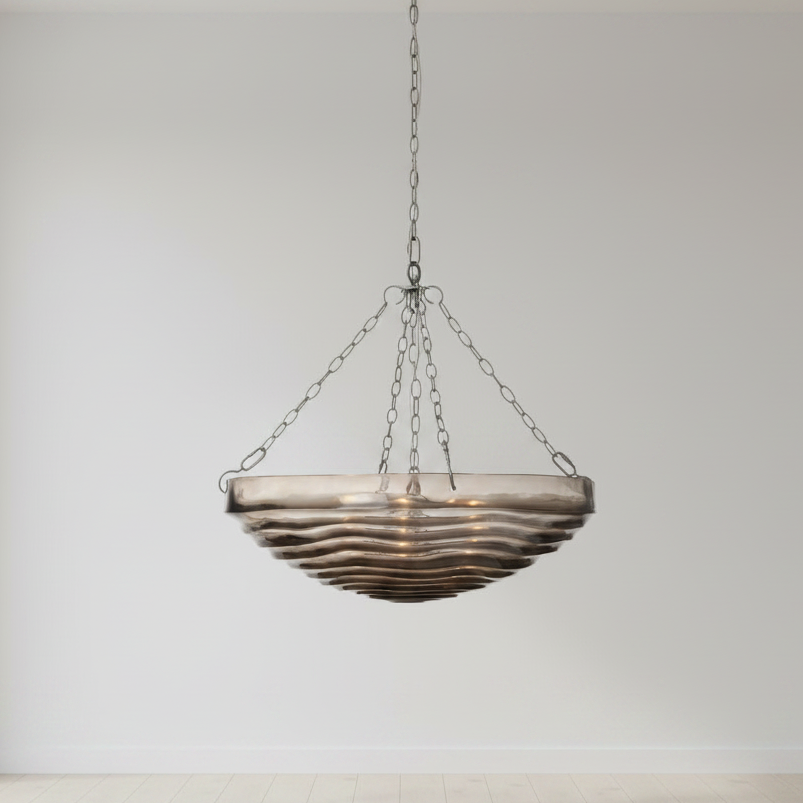 Decorative hanging light fixture with wavy glass shade on a plain background
