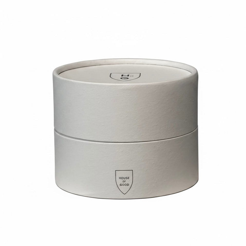Round white candle container with a logo on a white background