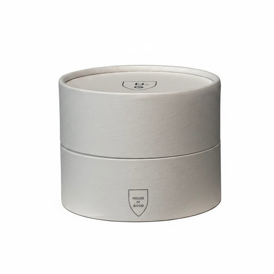 Round white candle container with a logo on a white background
