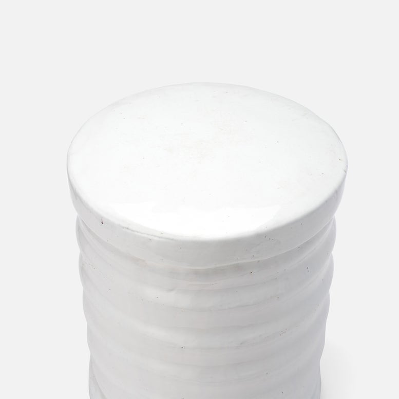 White cylindrical container with a textured surface on a white background