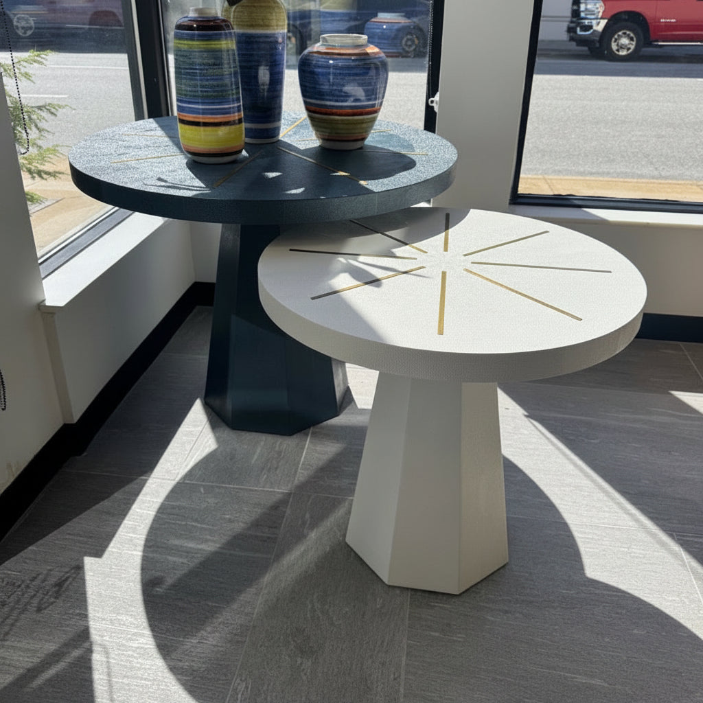 Two tables with decorative vases in a room with large windows.
