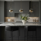 Osbourne Bar Stool Black Leather in moody kitchen setting with Arteriors pendants and vase
