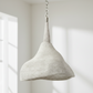 Textured pendant light hanging in a room with natural light