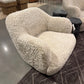 Modern textured armchair on a patterned rug with a blurred background