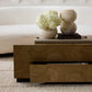 Wooden coffee table with decorative items including a vase of flowers and textured balls on a neutral background.