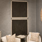Two large rectangular wall art panels with black and beige geometric line patterns, displayed side by side on a textured gray wall above two upholstered chairs.