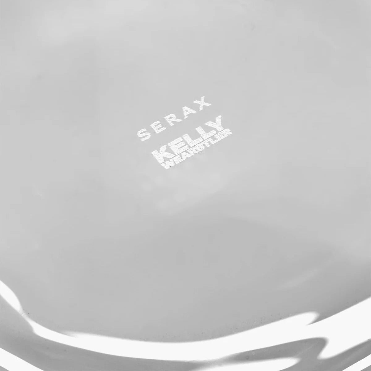 Close-up of a gray surface with 'Serax Kelly' branding.