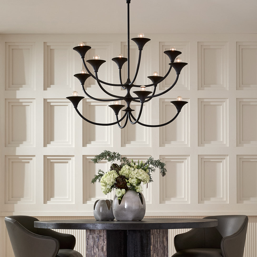 Dining room with a black chandelier, round wooden table, and gray chairs.