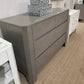 Gray dresser with decorative items in a room setting