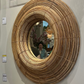 Round woven mirror on a wall with price tags