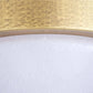 Close-up of a gold circular object with a textured white surface below