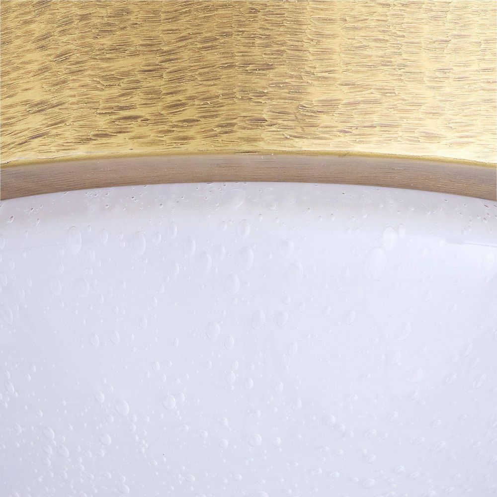 Close-up of a gold circular object with a textured white surface below