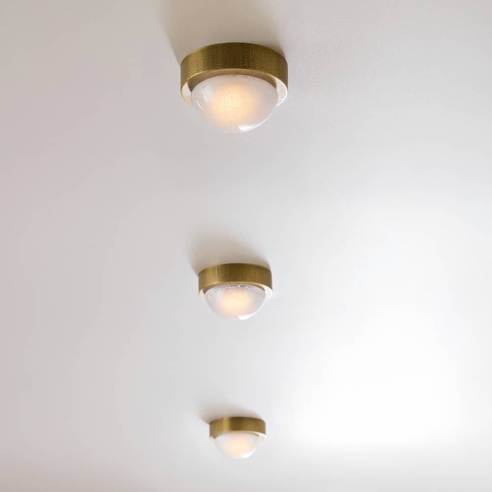 Three gold ceiling lights on a white ceiling
