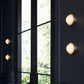 Modern wall lights on a dark wall with a window in the background