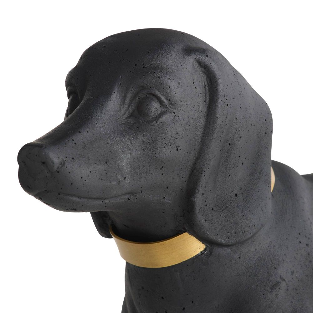 Black dog figurine with a gold collar on a white background
