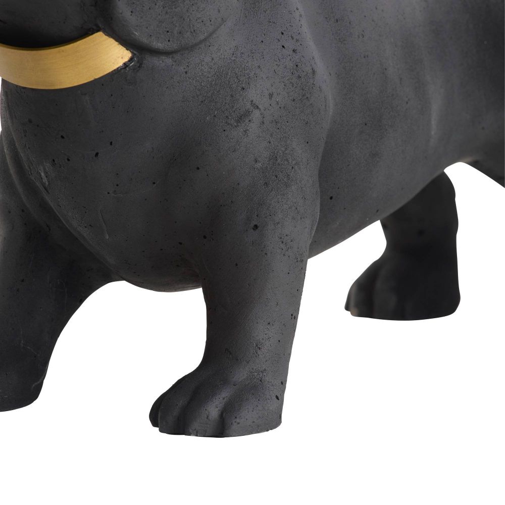 Close-up of a black dog figurine with a gold collar on a white background