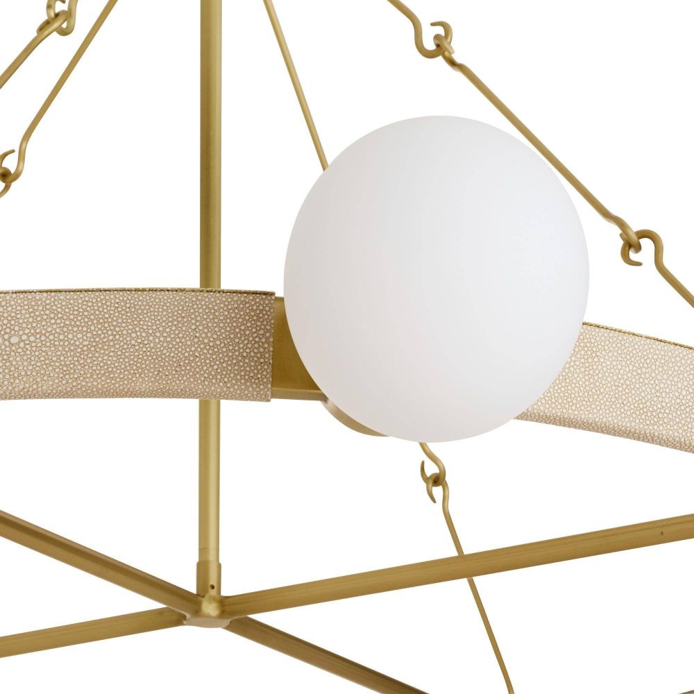 Gold chandelier with a white glass globe on a white background