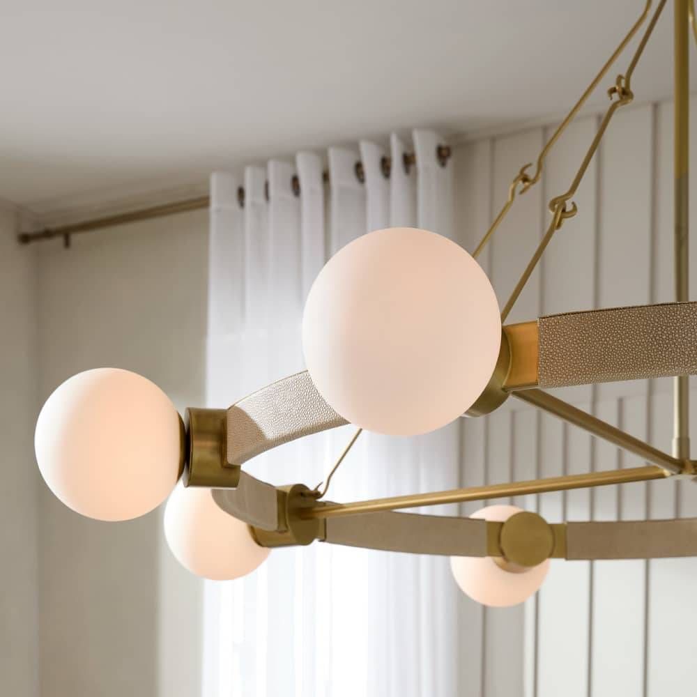 Modern chandelier with gold and bronze fixtures against a neutral background