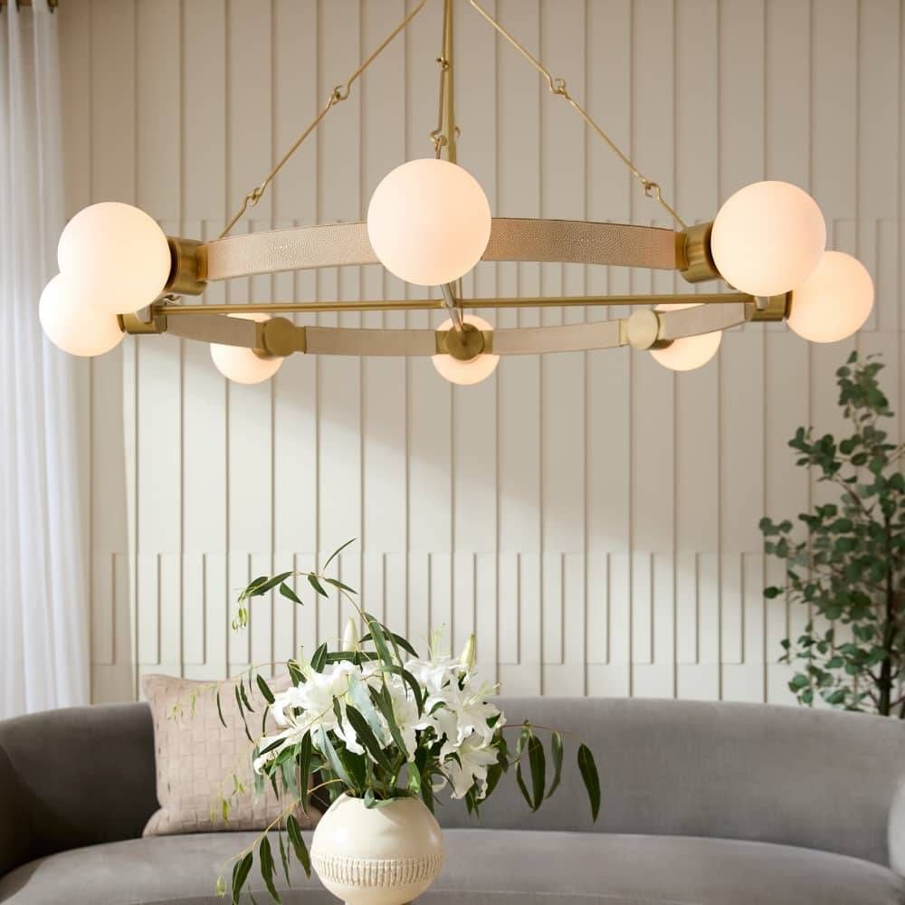 Modern chandelier with spherical lights in a living room setting.