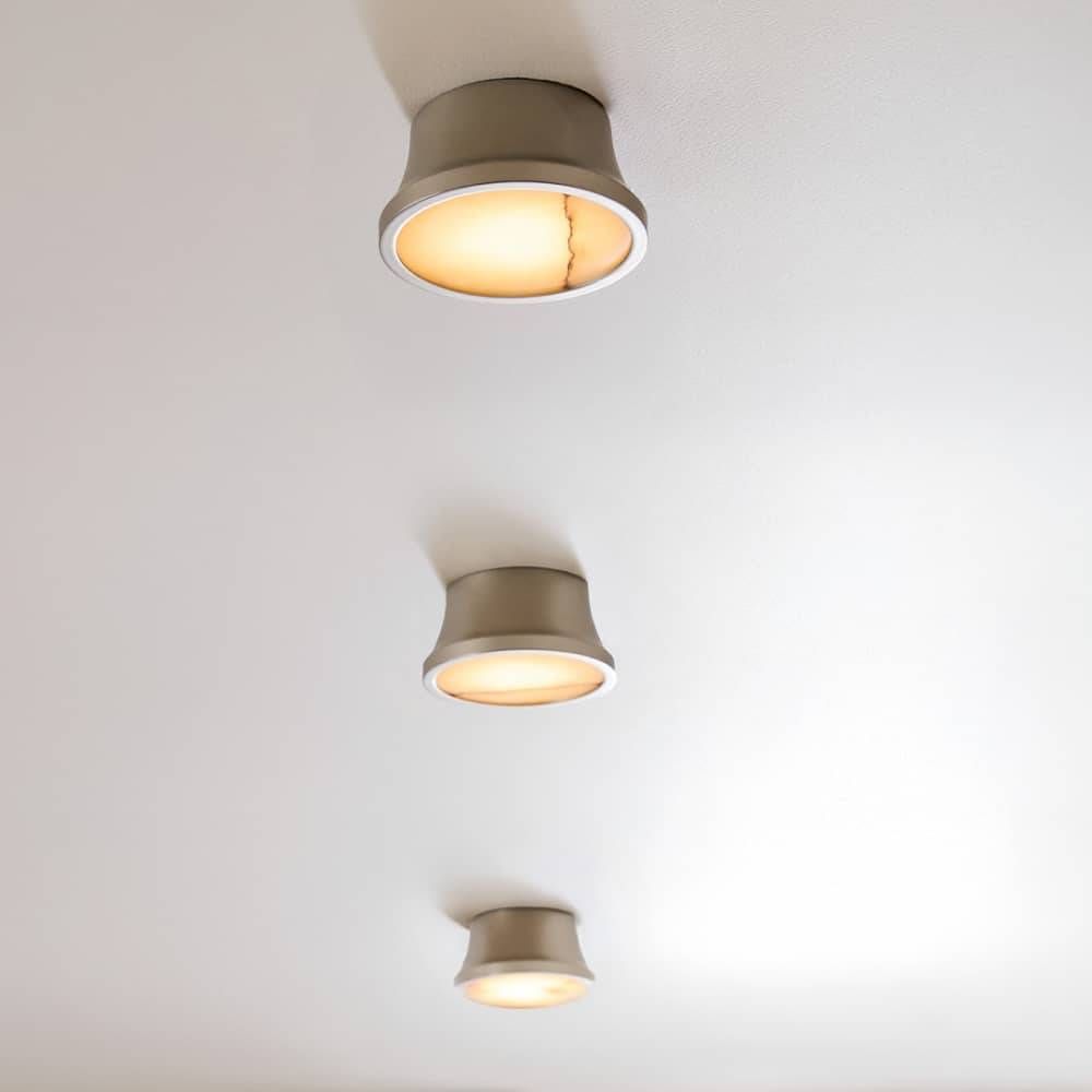 Three ceiling lights with beige fixtures on a white ceiling