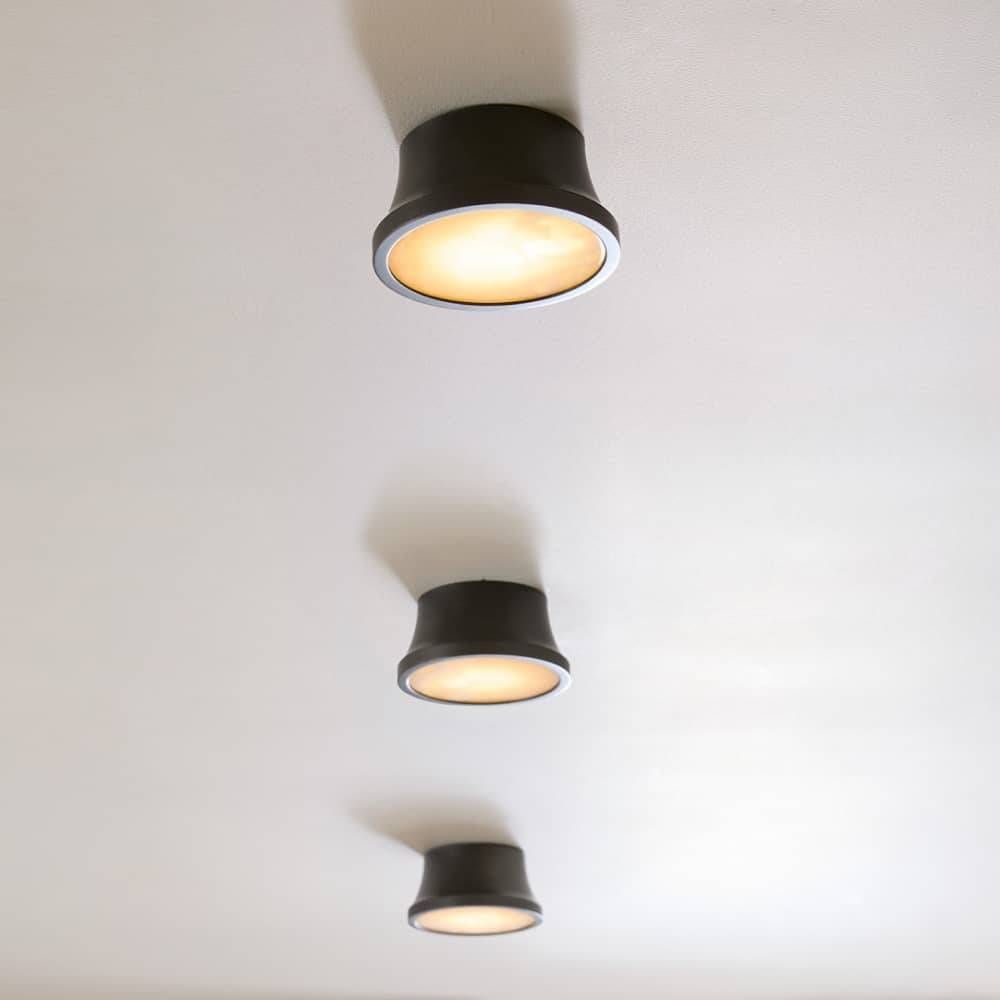Three black ceiling lights on a white ceiling