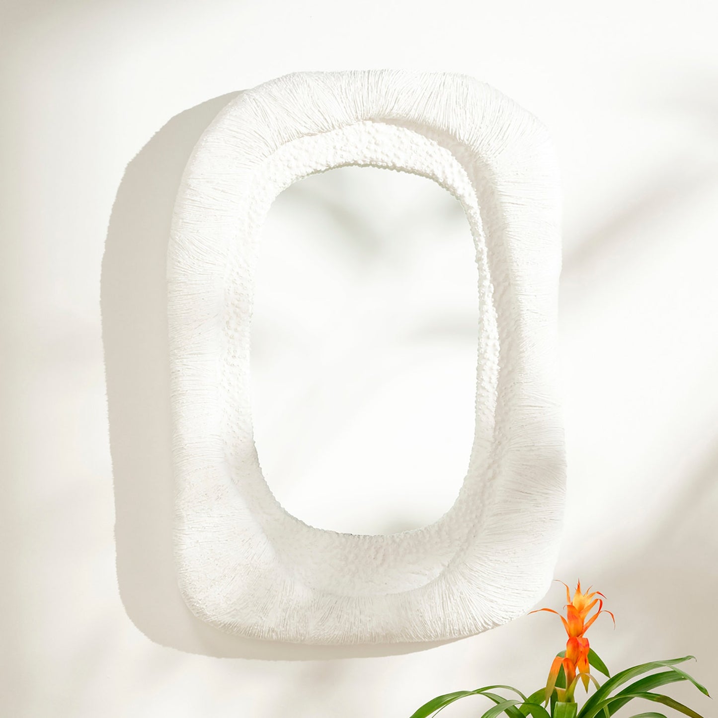 White square pillow with a plant on a light background