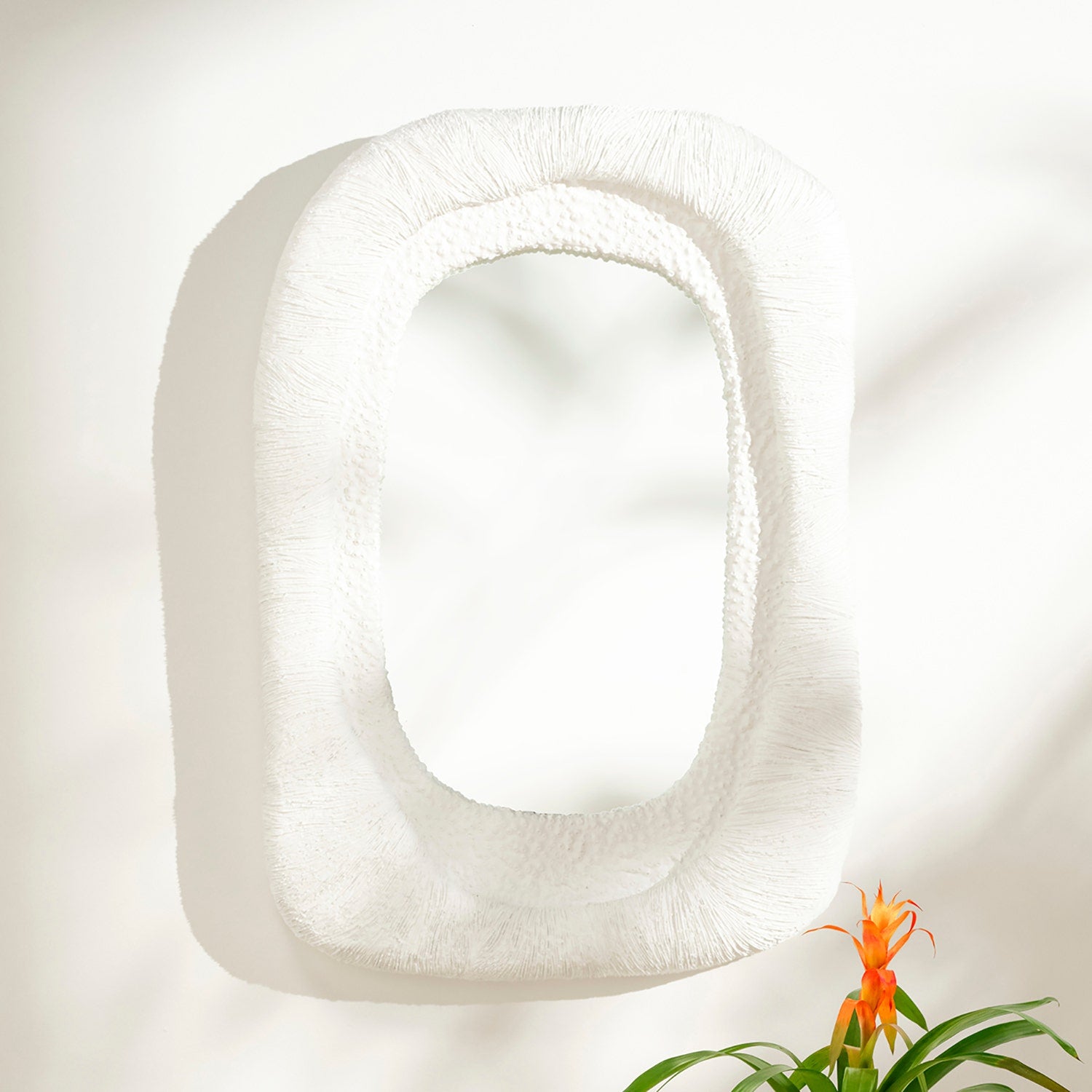 White square pillow with a plant on a light background