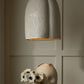 Decorative ceramic lamp with textured design on a neutral wall.