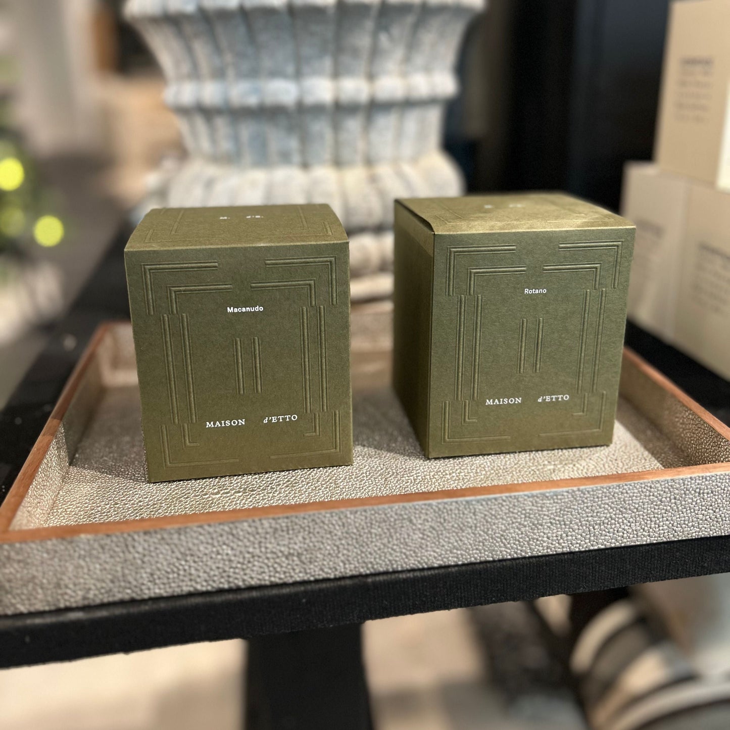 Two green boxes on a textured surface with a blurred background