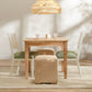 Dining area with wooden table, chairs, and ottoman under a pendant light.